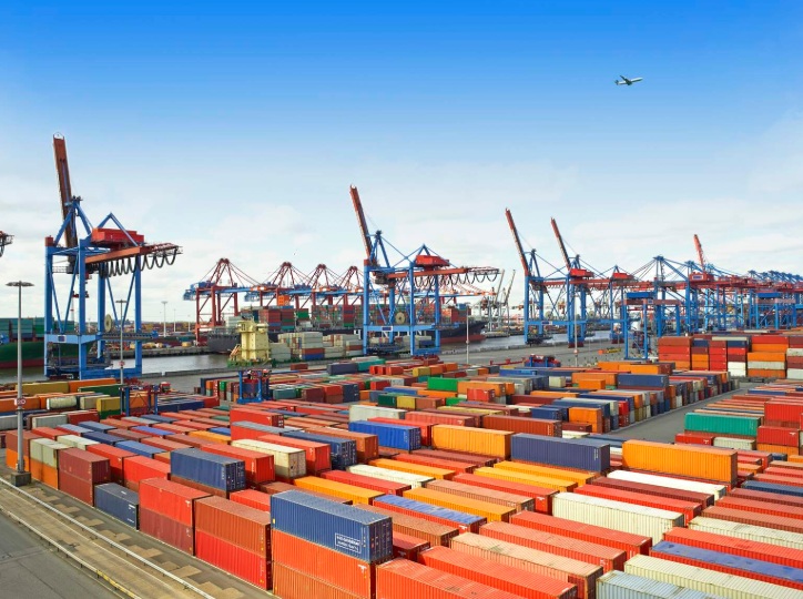 Patio de contenedores y grúas de puerto en una terminal de carga internacional